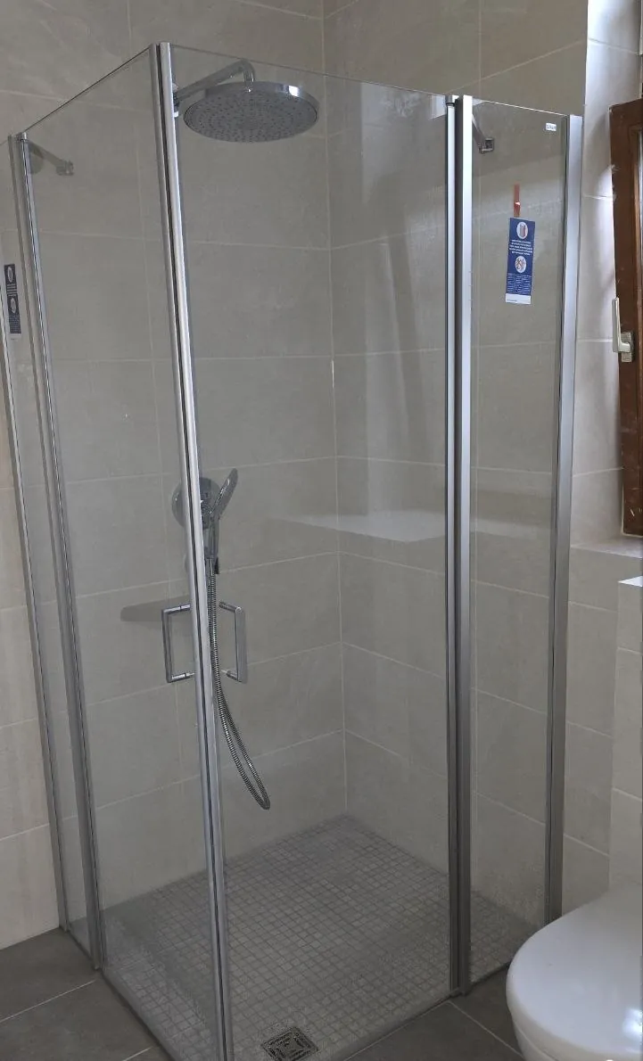 Eckdusche mit Glaswänden und Regenbrause