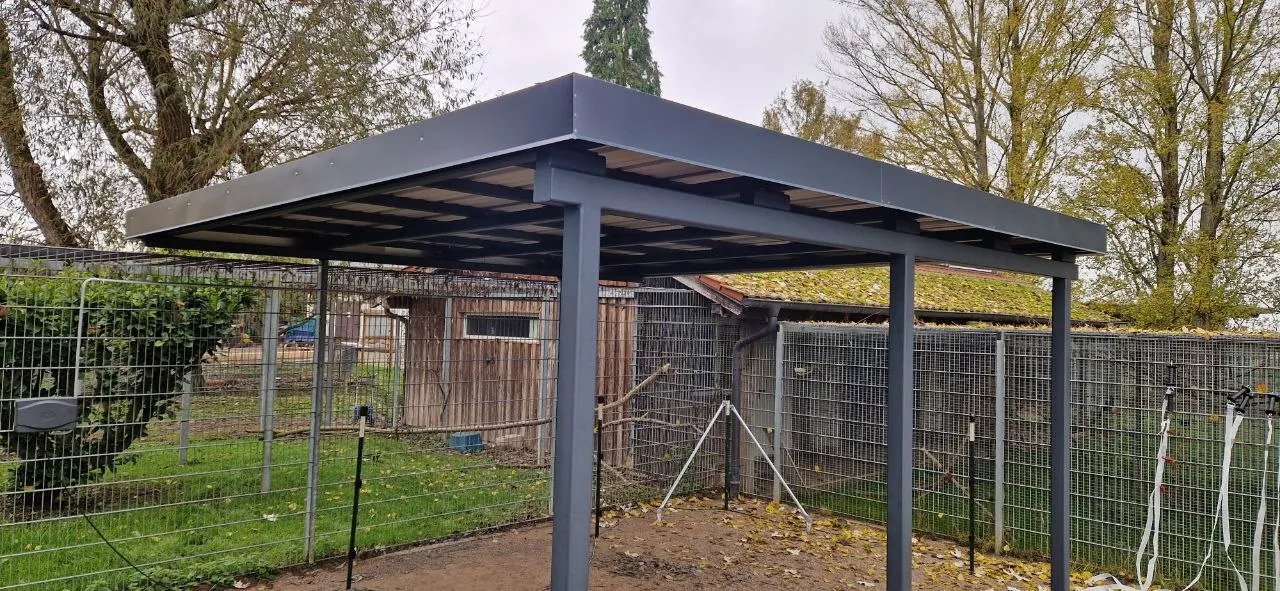 Grauer Stahl-Carport, im Garten montiert