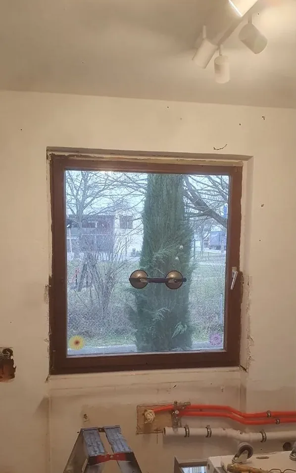 Vorher: altes braunes Holzfenster in der Rohbauwand
